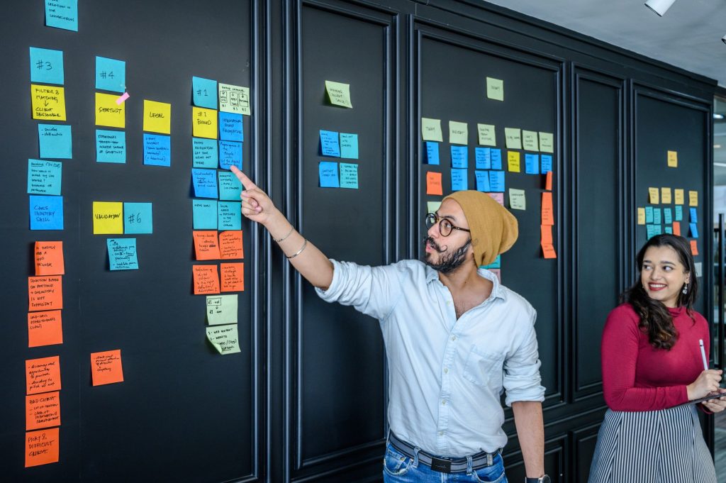 Team discussing project strategies with colorful sticky notes on board.